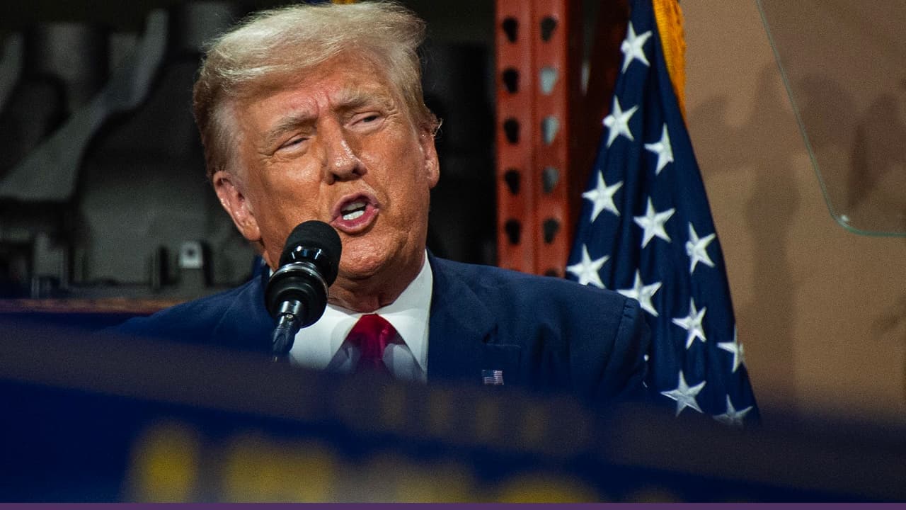 Donald Trump speaking at podium with US flag backdrop