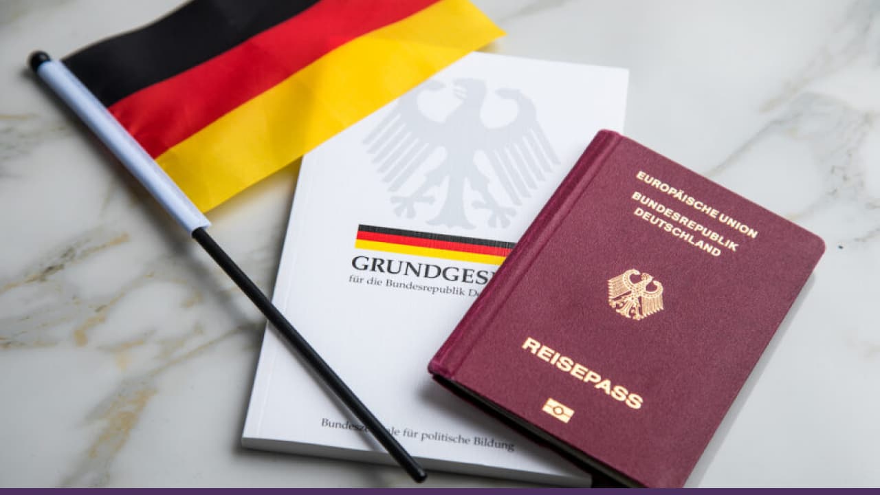 German passport, national flag, and constitution booklet representing German immigration and citizenship process