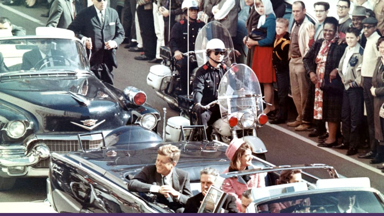President John F. Kennedy and First Lady Jacqueline Kennedy ride in a motorcade through Dallas, Texas, shortly before his assassination.