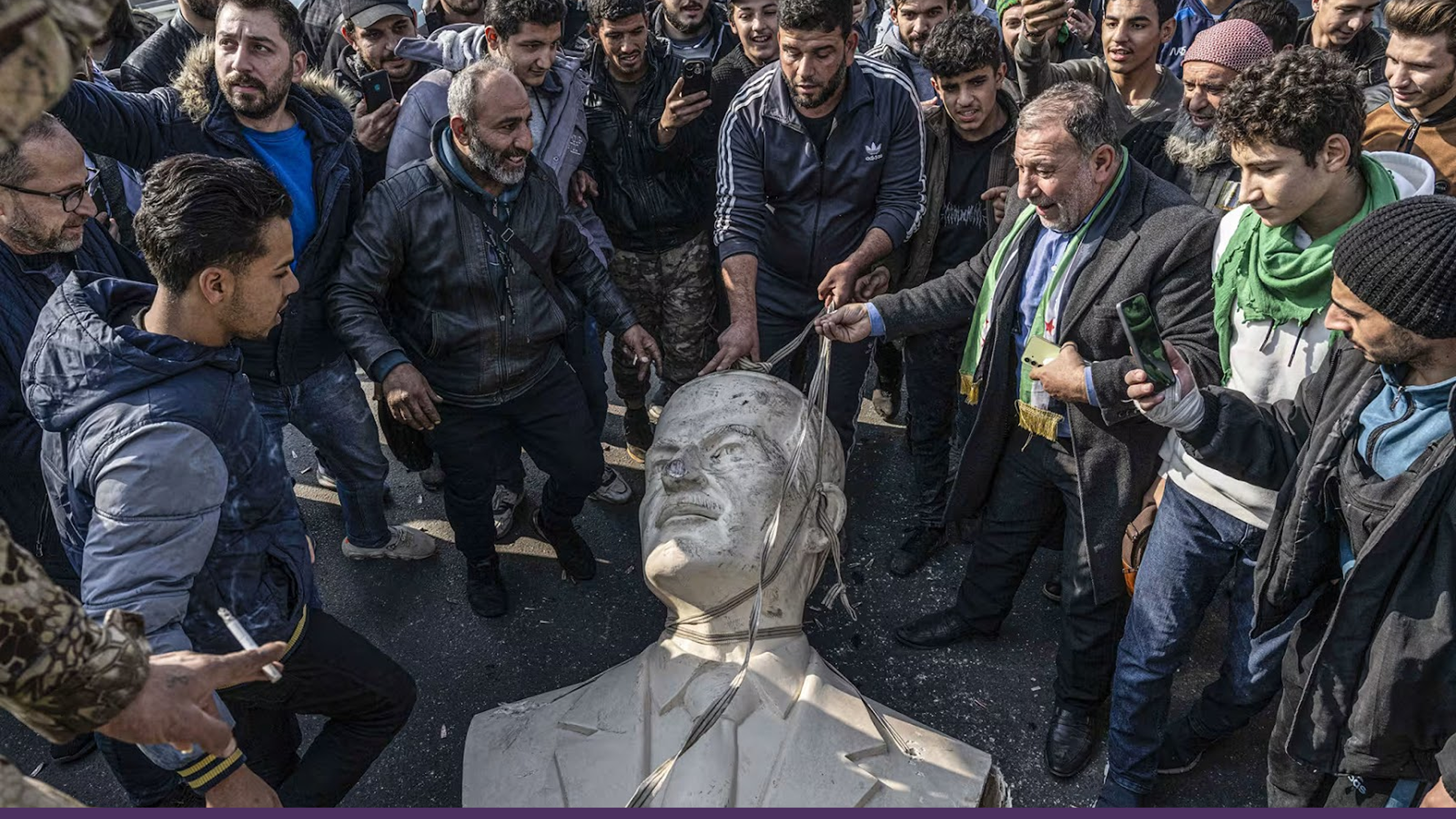 Syrians remove a statue of Hafez al-Assad, the father of Bashar al-Assad, in Damascus on Monday.